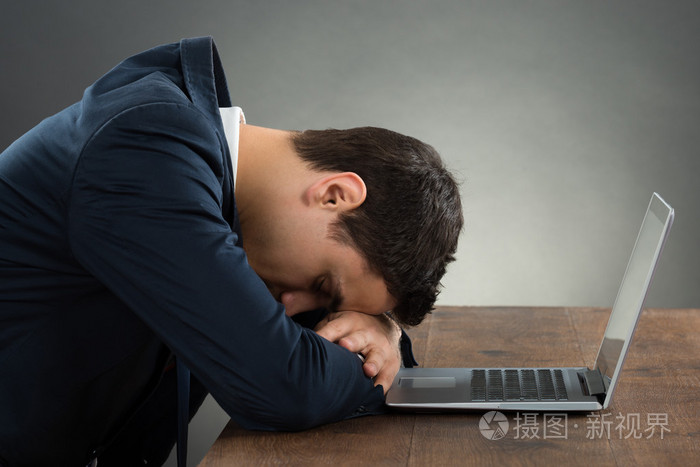 精疲力竭的商人,靠在桌子上