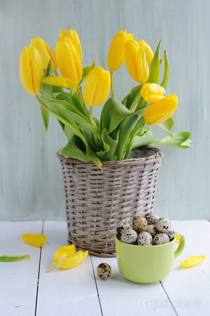 复活节装饰鹌鹑蛋花和杯子在桌子上