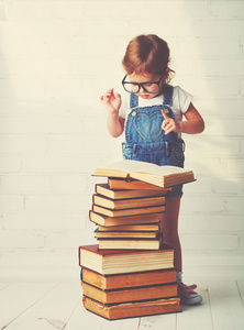 儿童小女孩戴着眼镜看书