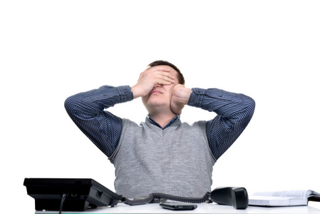 年轻的上班族,疲惫地坐在他办公桌前照片