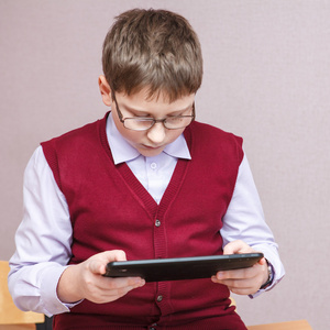 在一款平板电脑在学校玩的男孩