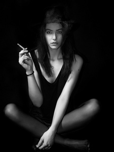 美丽的女孩画像坐着抽烟黑色和照片