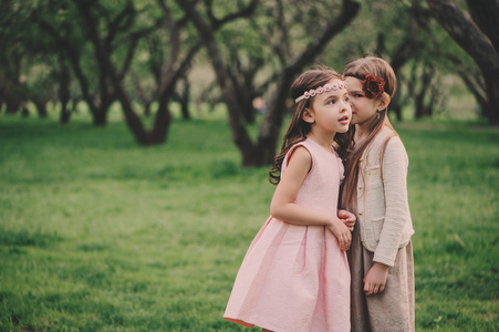 两个小孩女友告诉春天公园里的秘密泄露给对方。小考究姐妹花时间户外