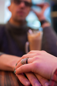 对夫妇手牵着手在咖啡馆