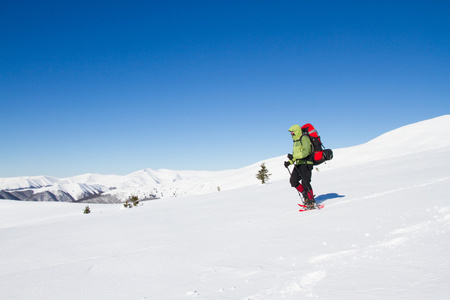 在山里徒步旅行带着背包和帐篷雪的冬天