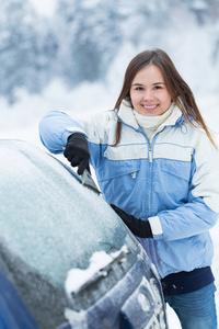 美丽的年轻女子，从她的车除雪