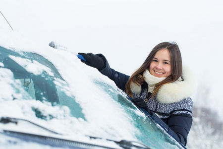 美丽的年轻女子，从她的车除雪