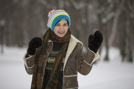 在严寒的冬季公园的美丽女孩。户外活动。纷飞的雪花