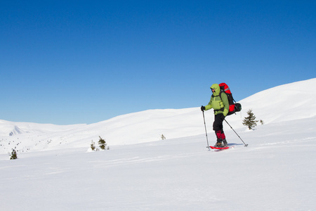 在山里徒步旅行带着背包和帐篷雪的冬天