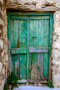 在老式的石墙绿色木质门的细节