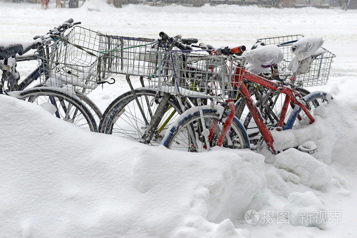 雪覆盖的自行车在暴风雪中链接在一起