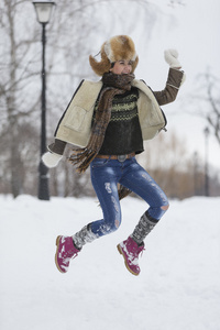 在严寒的冬季公园的美丽女孩。户外活动。纷飞的雪花