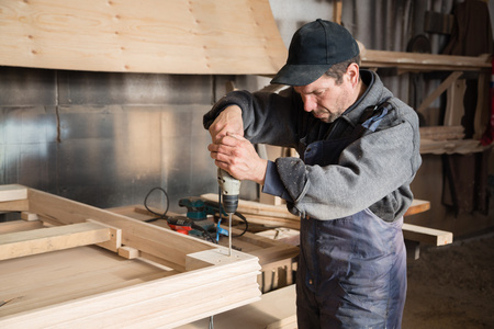 木匠组装木制家具，专注于手钻