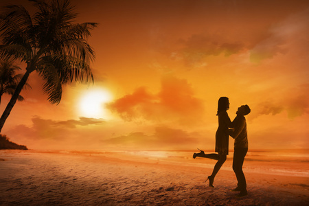 在海滩上的年轻夫妇剪影