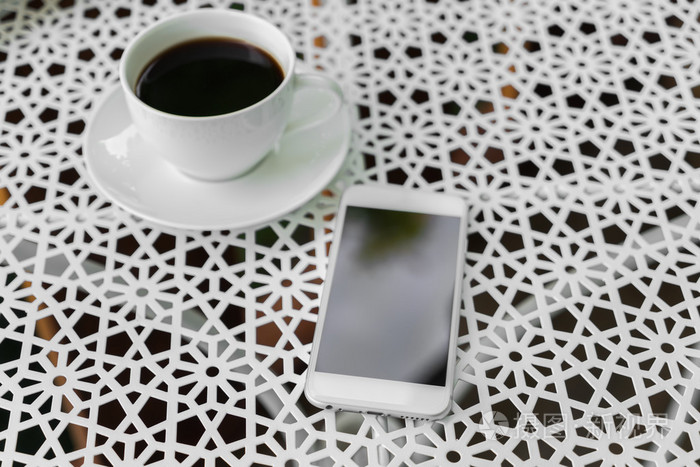 随着智能手机在桌上的咖啡