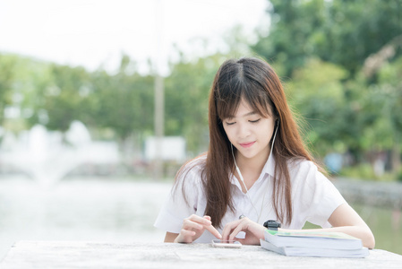 使用智能手机的制服的亚洲学生