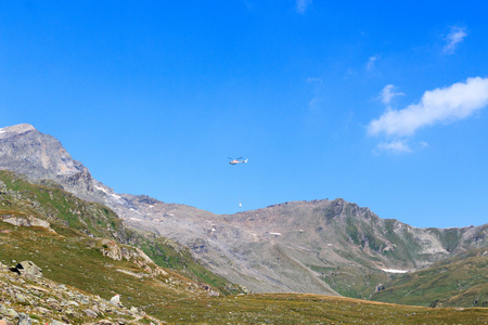 运输直升机飞行与用品和在奥地利陶恩山阿尔卑斯山全景