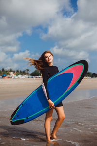 穿着冲浪板的湿衣服的女孩