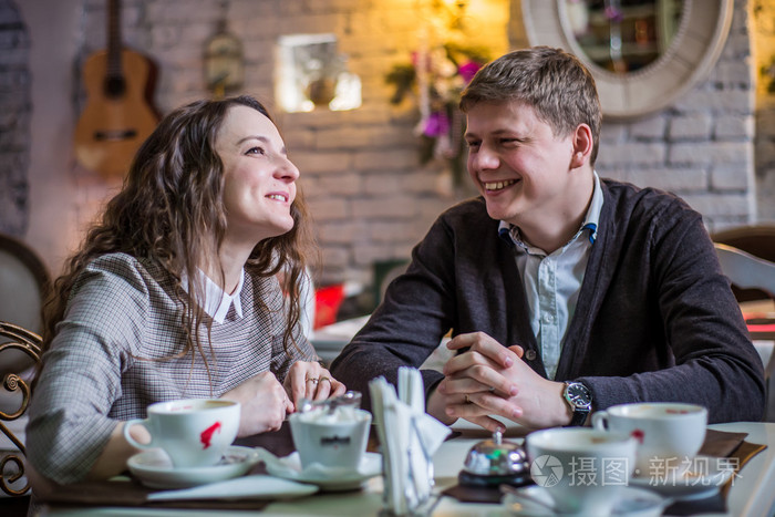 动情的年轻男人和女人在浪漫的约会,在一家咖啡馆