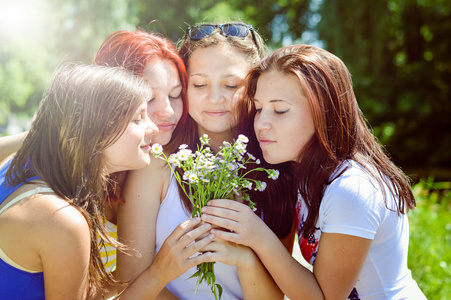 四快乐漂亮的朋友玩在绿草的花