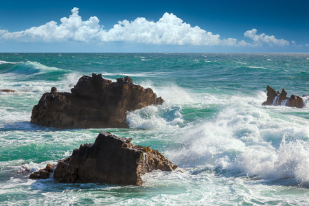 美丽的绿松石海浪岩石的海岸线和蓝色的天空