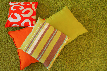 色彩鲜艳的靠垫，绿色的地毯上