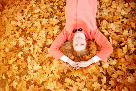 秋天的女人在背景上落叶的树木。 模型模型
