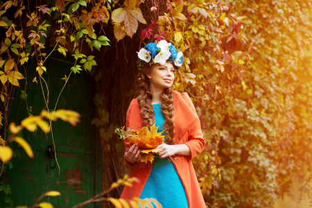 秋天的模型，明亮的弥补。女人对背景秋季景观树的树叶。秋季女孩模型。时尚界人士