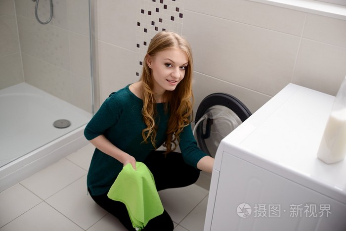 女人把脏衣服放进洗衣机