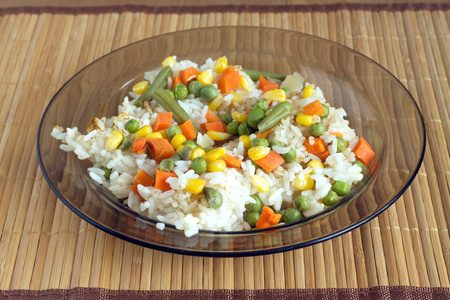 在柳条垫上白米饭与蔬菜在板上