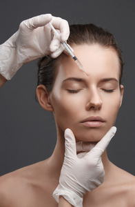 整容手术美女用整容,描摹,整形医生之手美女脸上打针.