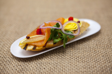 新鲜的西班牙小吃面包面包熏制挪威三文鱼与黑橄榄色黄油, 草药和洋葱。菜单餐厅地中海咖啡厅美食的绝佳背景