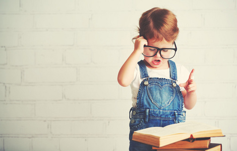 儿童小女孩戴着眼镜看书