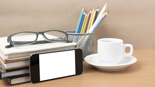 咖啡，电话，眼镜，堆栈的书和彩色铅笔