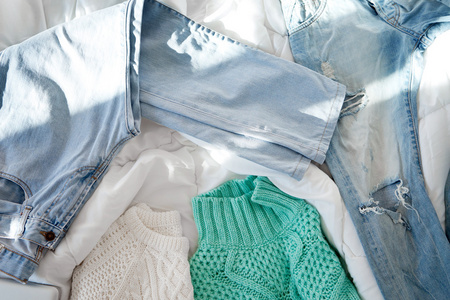 女性的衣服摆放在床上照片