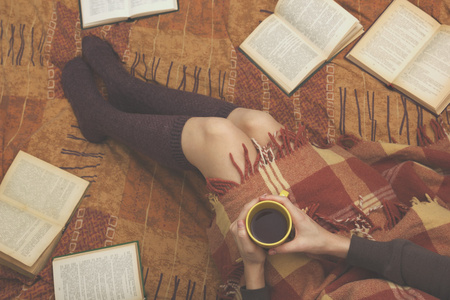 女人在床上老书，在手中，顶视图点杯咖啡。复制文本的空间。软的照片