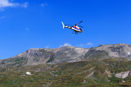 运输直升机飞行与用品和在奥地利陶恩山阿尔卑斯山全景