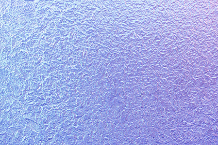 在冬天的霜在窗户玻璃上的图案。磨砂玻璃纹理。蓝紫色