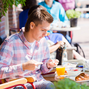 年轻人在欧洲城市在户外咖啡馆吃早餐