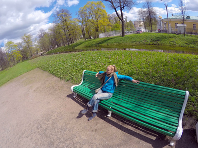 春天, 那个穿着蓝色夹克的女人在公园的长椅上