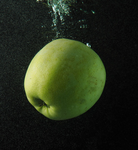 在深色背景上的泡沫水中的苹果