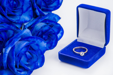 蓝色天鹅绒盒子和蓝色玫瑰的金色订婚戒指
