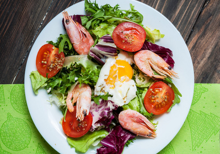 健康的虾和芝麻菜沙拉配番茄木制的桌子上