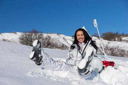 女子滑雪运动员坐着享受温暖的阳光下