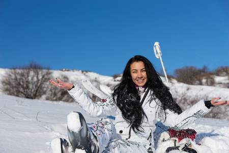 女子滑雪运动员与开放武器享受温暖阳光