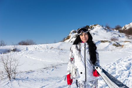 雪山上拿着滑雪板和滑雪杆的女人