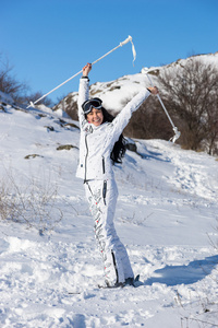 滑雪板上的女人在山坡上举着杆子