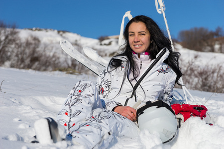 女子滑雪运动员坐着享受温暖的阳光下
