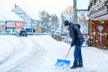 人与雪铲清除人行道在冬天