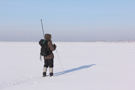 人与河的雪地上滑雪背包旅行